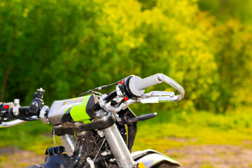 part of an extreme off-road motorcycle on a background of trees. motorcycle gas handle and brake system handle with protection