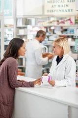 Peel and stick wall murals Pharmacy Wellness, health and happy pharmacy customer at store counter for medicine expertise with smile. Pharmaceutical advice and opinion of woman pharmacist helping girl with medication information.