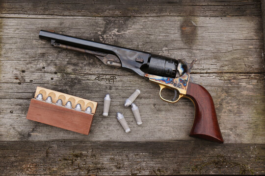 Black powder revolver and cartridges on an old board.