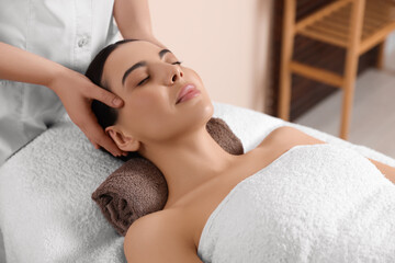 Fototapeta na wymiar Young woman enjoying professional massage in spa salon
