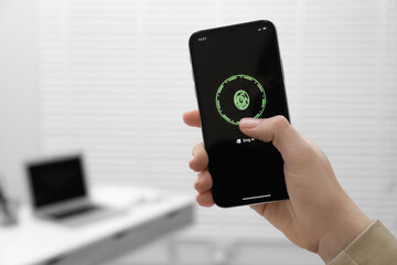 Woman unlocking smartphone with fingerprint scanner indoors, closeup. Space for text