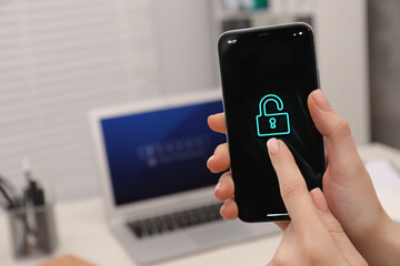 Woman holding smartphone with blocked screen at workplace, closeup. Space for text