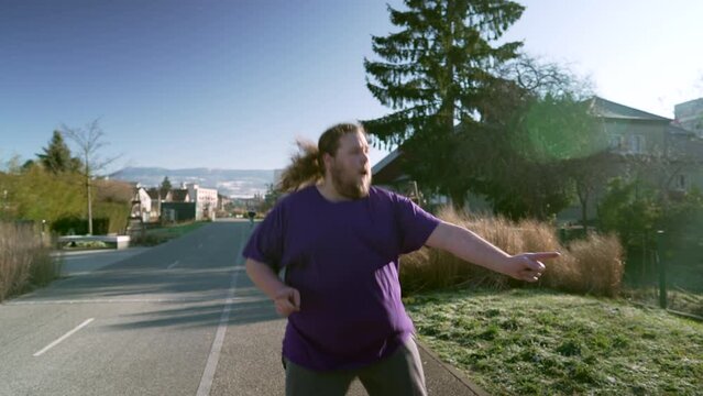 One happy overweight man dancing outside in street. A fat Person celebrating good news bouncing with joy