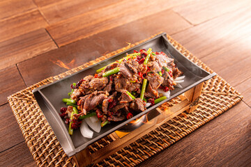 Spicy chilli Hunan Sizzling Beef served dish isolated on wooden table top view of Hong Kong food