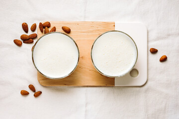 Two glasses of vegan almond milk and nuts.