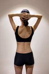 Head in hands, Back view of slim fit female body with black sportswear