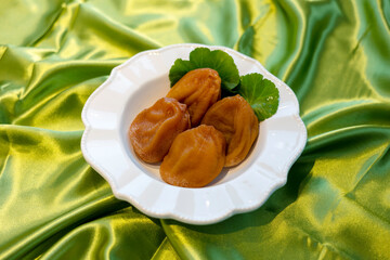 White plate of Dried Persimmon on the green fabric