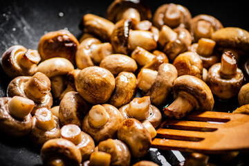 Mushrooms are fried in a frying pan. 