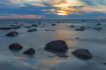 Rocky shore of Baltic sea at sunset, sky is full of clouds, blue mood, long exposure. Viimsi,...