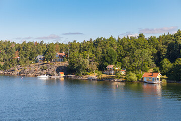 Fototapeta na wymiar Stockholm Archipelago, view from the cruise ship. Cottages on the shore