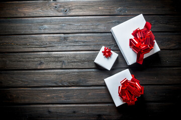 White Christmas gift boxes with red bows.