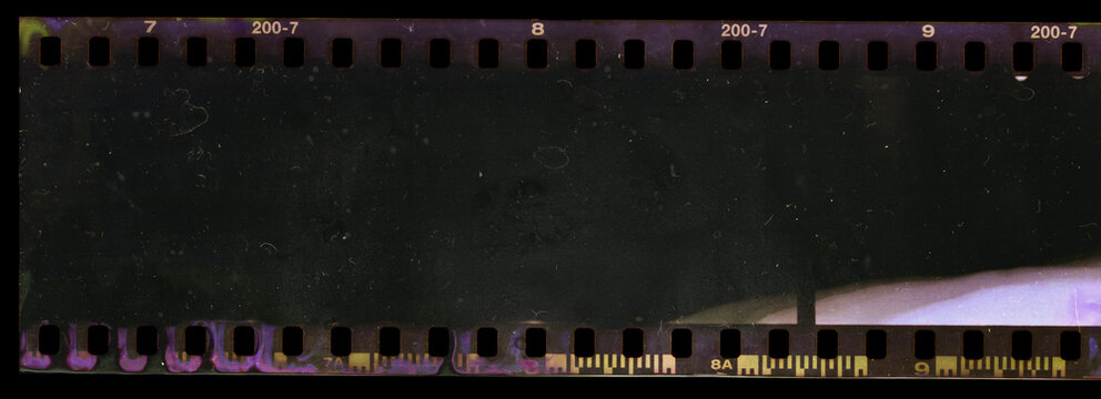 underexposed 35mm film strip on black background with smear marks, scratches and dust.