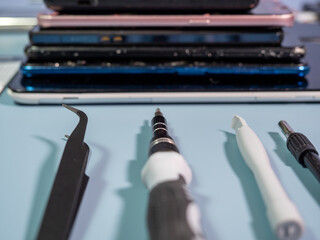 Old broken smartphone and repair tool. The concept of computer equipment, mobile phones,...