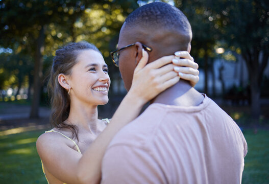 Love, park and smile with an interracial couple bonding outdoor together on a romantic date in nature. Summer, romance and diversity with a man and woman dating outside in a green garden