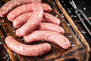 Raw sausages on a cutting board. 