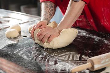 pizzaiolo prepares pizza in the kitchen, the chef prepares the dough