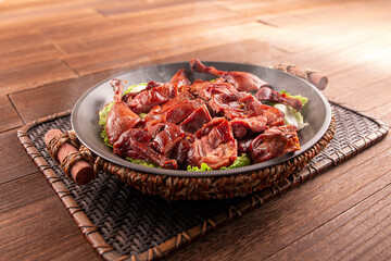 Spicy chilli Hunan style salted duck served dish isolated on wooden table top view of Hong Kong food