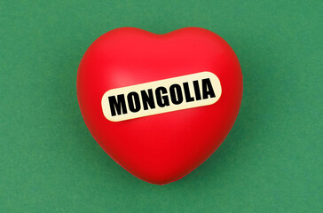On a green surface lies a red heart with the inscription - Mongolia