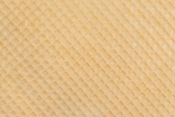 Fototapeta premium The texture of a brittle, beige waffle close-up. Material for cakes and pastries. Place for your design