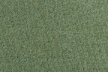 Texture of green woolen fabric close-up. Material for warm winter sweater. Place for your design