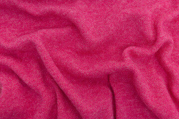 Fototapeta na wymiar Texture of crumpled woolen fabric of pink magenta color. Merino wool, cashmere concept. Background for your mockup