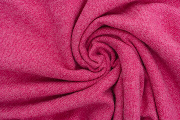 Fototapeta na wymiar Twisted woolen fabric of magenta color close-up. Cashmere, fabric for a warm sweater concept. Place for your design