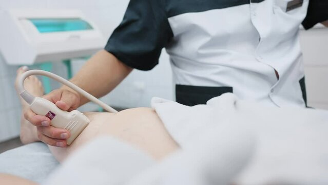 doctor does an ultrasound of the veins on the patient's legs. A phlebologist checks the veins on a woman's legs with an ultrasound machine in a modern clinic.