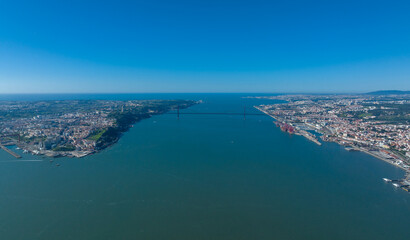 The 25 April bridge (Ponte 25 de Abril) located in Lisbon, Portugal, crossing the Targus river. Drone.