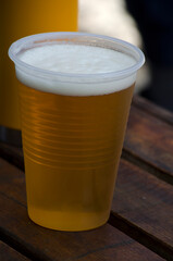 plastic beer glass, blonde beer in transparent plastic common glass
