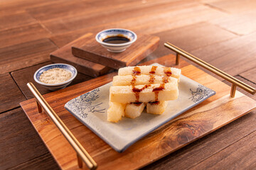 brown sugar glutinous rice cake with sauce served dish isolated on wooden table top view of Hong...