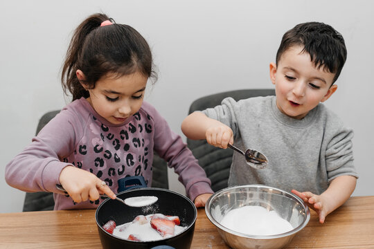 Portrait Of Two Happy Children Preparing Strawberry Jam, Eating Tasty Strawberry.