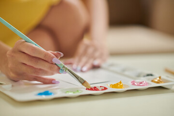 Naklejka premium Closeup image of woman painting pictures at home to decorate house