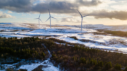 Aerial view of wind turbines on a snow covered hillside in Wales