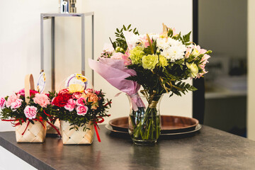 Flower bouquets and baskets standing on the bar counter