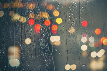 raindrops on the window and street lights background at night