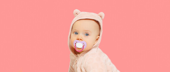 Fototapeta Portrait of cute little baby in soft costume with pacifier on pink background obraz