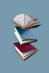 books with blue and red binding fly on a blue background