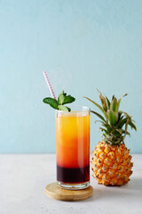 Pineapple summer drink cocktail with straw, mint leaf and fruit