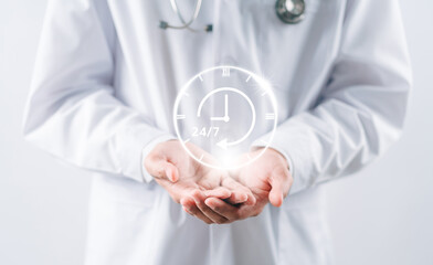 Doctor in a white coat uniform holding 24/7 service icon for assistance patient when accident or emergency, Medical call center service without interruption day and night.