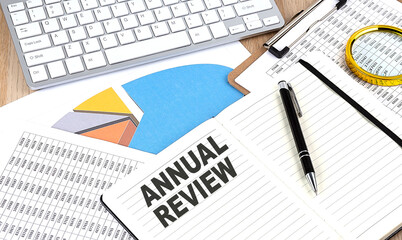 ANNUAL REVIEW text on notebook with chart and keyboard