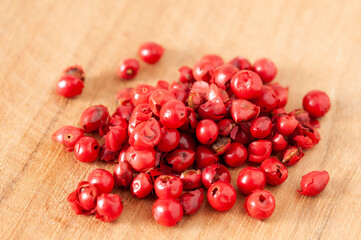 Rosa Pfefferbeeren auf einem Holzuntergrund