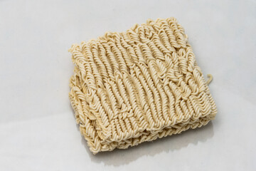 Dry instant ramen noodles on white background.