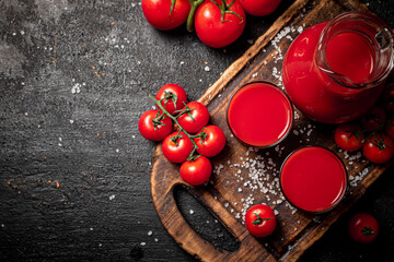 Glasses of tomato juice on a cutting board. 