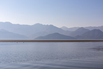 Scenic view on beautiful lake of Skadar National Park on sunny autumn day seen from Vranjina, Bar, Montenegro, Balkans, Europe. Travel destination, Dinaric Alps near Albania. Magical water reflection