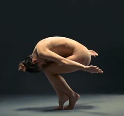 Body, nude and ballet with a model woman in studio on a dark background for dance or performance...