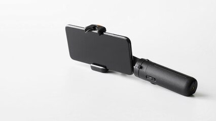 Modern mobile phone mounted on a gimbal to stabilize photo-video shooting and eliminate camera shake. White background.