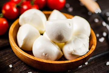 Mozzarella cheese on a plate on a table with tomatoes and spices. 