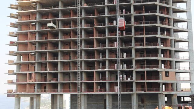 worker riding a construction elevator in construction Project