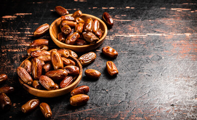 Delicious dates on a wooden plate. 