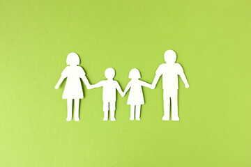 Familie mit Mutter, Vater und zwei Kindern, die sich an den Händen hält, als Silhouette aus...